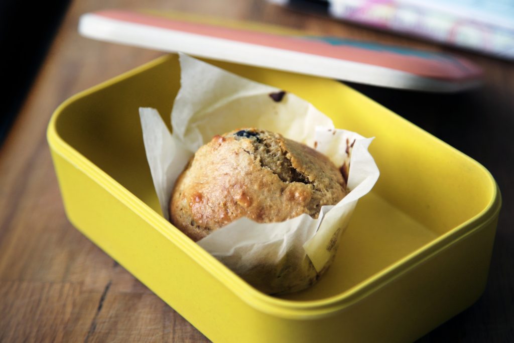 A muffin inside of a tight sealing plastic container.