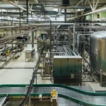 A clean, organized food processing facility with industrial machinery, stainless steel tanks, and conveyor systems, highlighting the need for tailored pest control solutions—contact Gregory Pest Solutions to learn more.