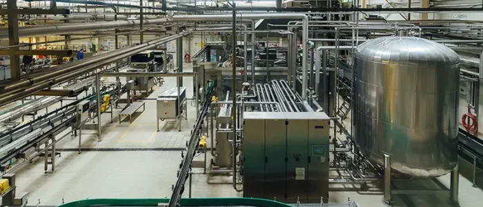 A clean, organized food processing facility with industrial machinery, stainless steel tanks, and conveyor systems, highlighting the need for tailored pest control solutions—contact Gregory Pest Solutions to learn more.