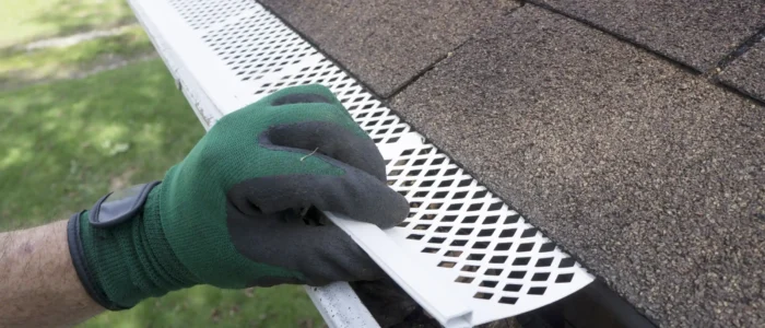 man adjusting gutter guard over gutter