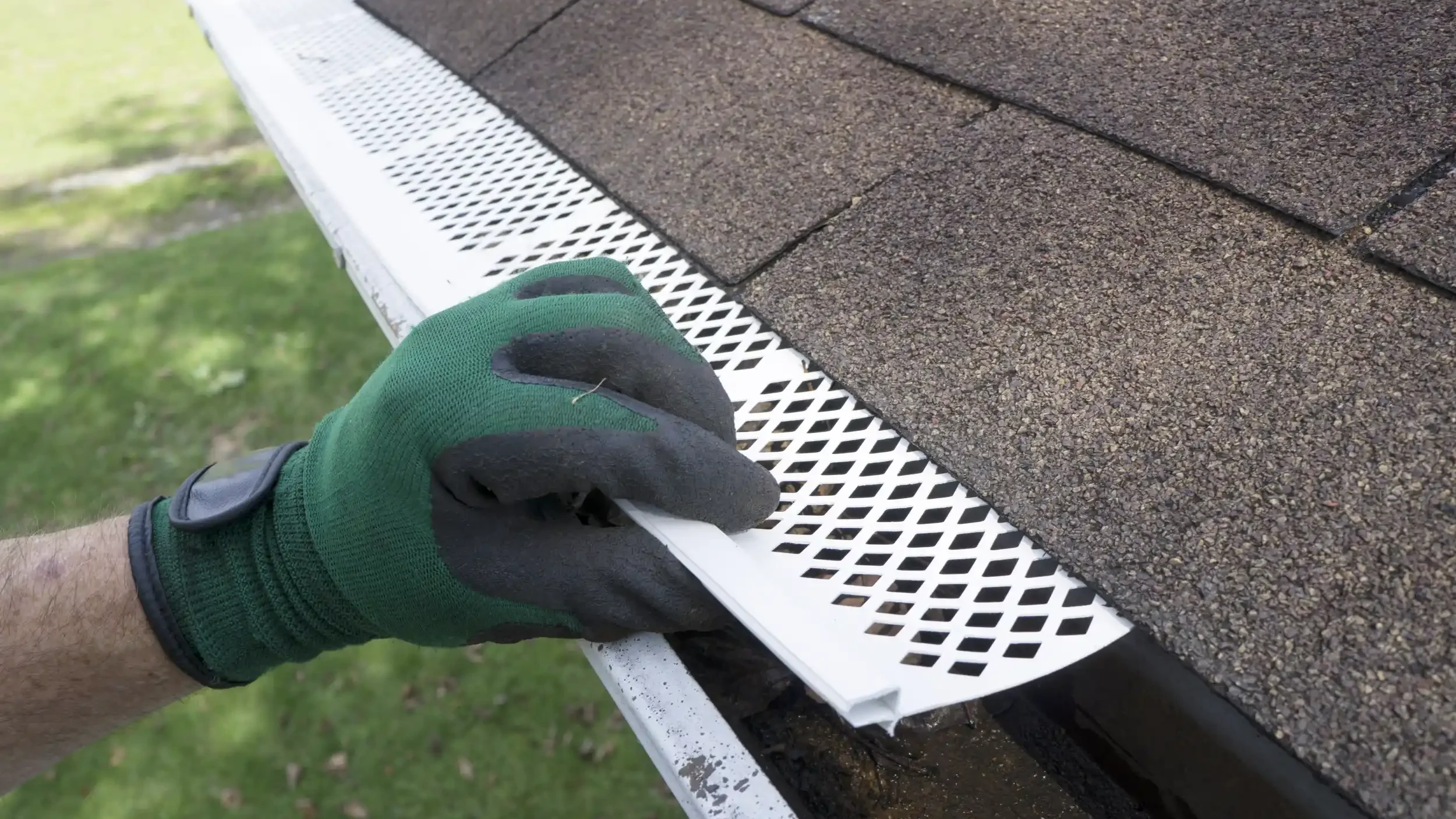 man adjusting gutter guard over gutter